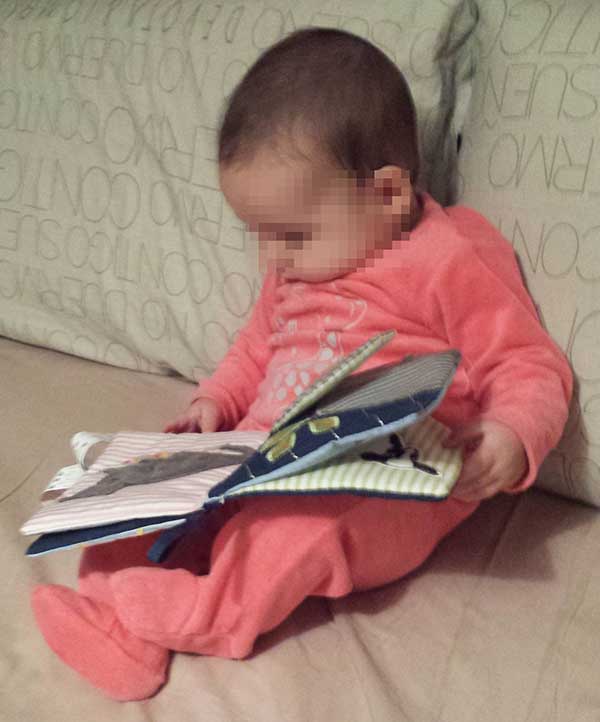 Bebé 5 meses con un libro de tela